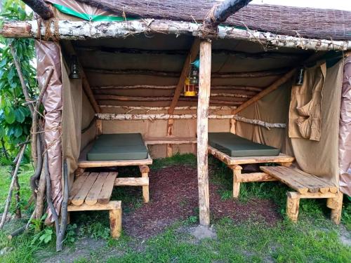 LabroyeAu Pied Du Trieu, The Shelter的两个长椅坐在帐篷内