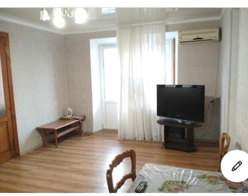 加格拉улица Абазгаа Апартаменты的客厅配有平面电视和桌子。