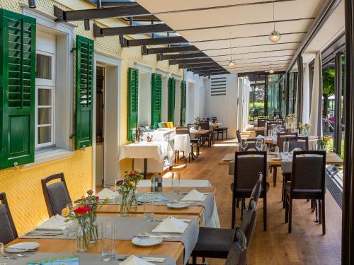 Egnach斯鲁斯特酒店的餐厅设有桌椅和窗户。