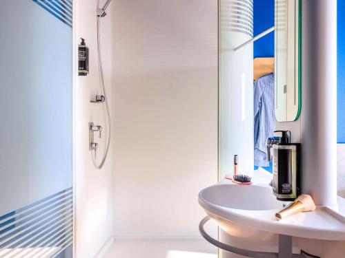 洛桑Ibis budget Lausanne-Bussigny的白色的浴室设有水槽和镜子