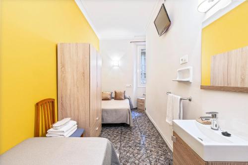 巴塞罗那亚圣安娜旅馆的一间带水槽的浴室和一间带床的房间