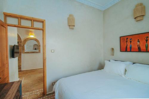 索维拉Stella 1 - joli appartement en médina avec cheminée的卧室配有白色的床和镜子