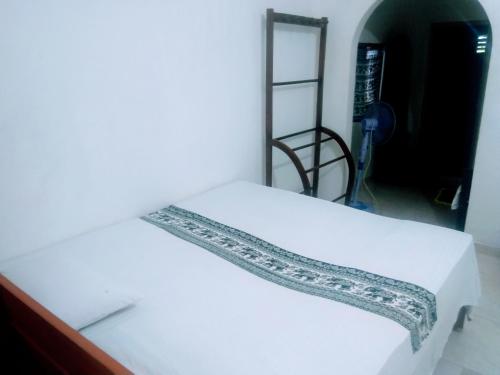 锡吉里亚Sigiriya Guest House Inamaluwa的白色的床,上面有花边装饰