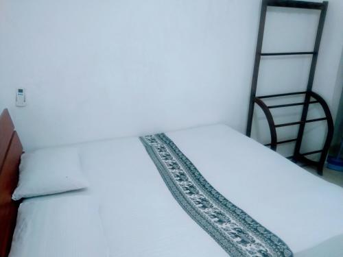 锡吉里亚Sigiriya Guest House Inamaluwa的一张白色的床,上面有图案的毯子