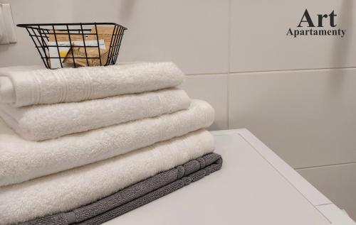 卡利什Art Apartamenty 1的浴室桌子上摆放着一堆毛巾