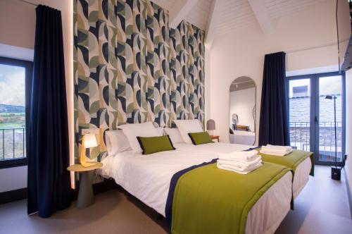 FriolHotel Rural O Cruce do Burgo的一间卧室配有一张带绿色和白色床单的大床