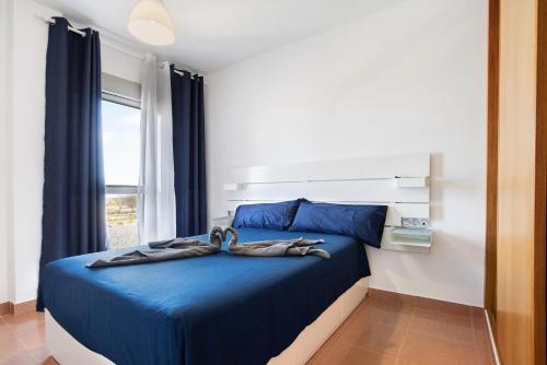 罗萨里奥港Casa Rosi 2的一间卧室配有蓝色的床和毛巾