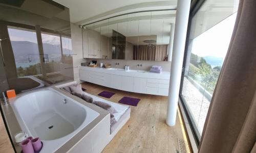 阿特湖畔努斯多夫Attersee Luxury Design Villa with dream views, large Pool and Sauna的一间带大浴缸和大窗户的浴室