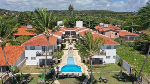 伊塔马拉卡Itamaracá Apartments的享有带游泳池的房屋的空中景致