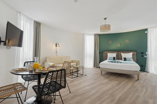 诺伊斯·勒·格兰德All Suites Noisy Le Grand的一间卧室配有一张床和一张桌子,设有用餐室