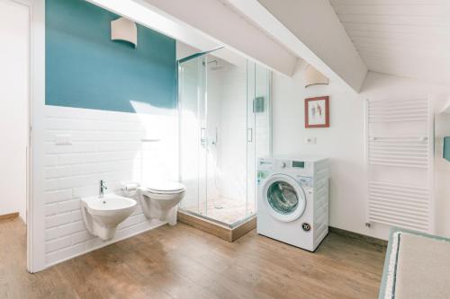 巴勒莫Addimora Boutique Suites的浴室配有卫生间水槽和洗衣机。