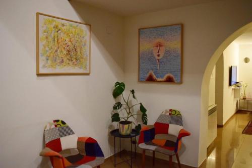 泰拉维Hestia - Hotel, Wine and View的走廊上设有两把椅子和一张桌子,种植了植物
