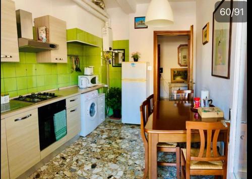 梅斯特Pang's Guesthouse的厨房配有桌子和白色冰箱。