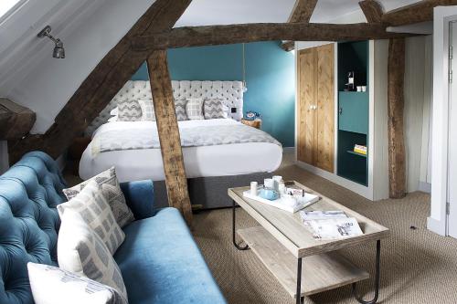 斯托昂泽沃尔德古士托克斯酒店的一间卧室配有一张床和一张蓝色的沙发