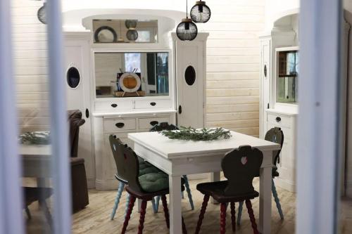 沃利乌格乡Vila Relax Valiug Crivaia的一间配备有白色桌椅的用餐室