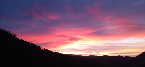 VillatellaAgriturismo Vecchio Frantoio的紫色和红色天空的山中日落