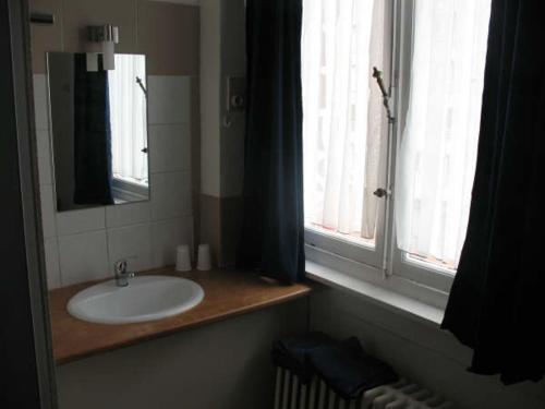 布兰肯贝赫罗基斯龙岛酒店的一间带水槽和镜子的浴室以及窗户。