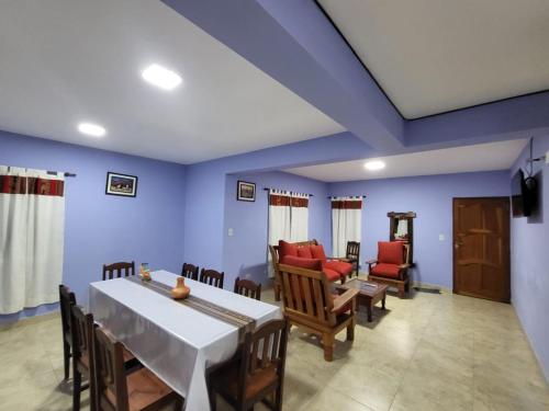 圣萨尔瓦多德朱La Glorieta -Casas de descanso的一间拥有蓝色墙壁和桌椅的用餐室