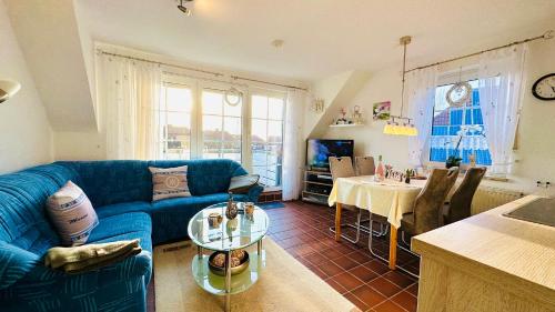 诺登Küstenliebe的客厅配有蓝色的沙发和桌子