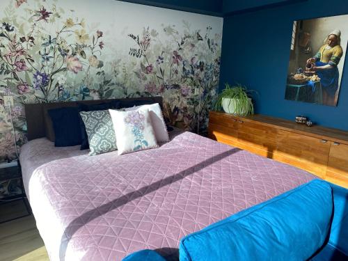 海伦芬BzB Jantina的一间卧室配有一张带紫色棉被的床