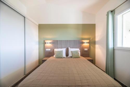 博尼法乔Résidence Santa Monica的一间卧室配有一张大床和两个枕头