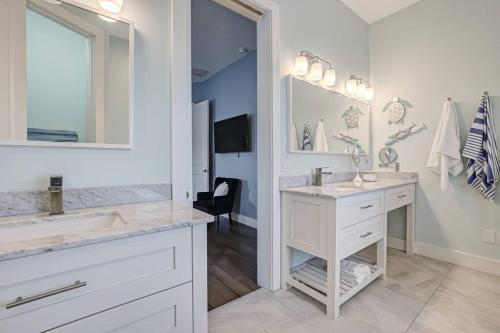圣奥古斯丁Sunkissed Sands的白色的浴室设有两个盥洗盆和镜子