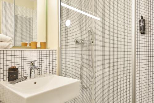 奥贝维利埃ibis budget Paris Porte d'Aubervilliers的白色的浴室设有水槽和淋浴。