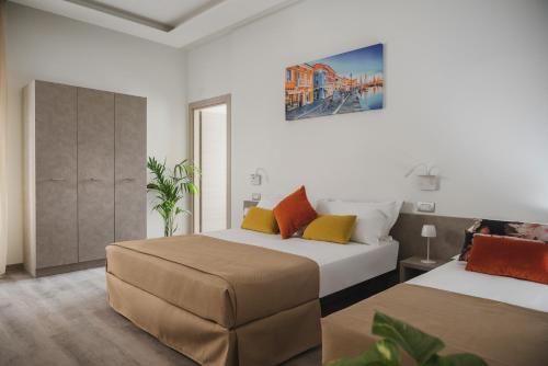 切塞纳蒂科Nido Suite & Apartments的一间卧室设有两张床,墙上挂着一幅画