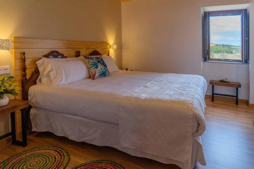 欧罗尔O Viso Ecovillage - Hotel Ecologico Vegano的卧室设有一张白色大床和一扇窗户。