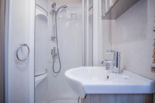 安姆罗斯Ty Moselle 12 - 2 Bedroom Holiday Home - Amroth的白色的浴室设有水槽和淋浴。