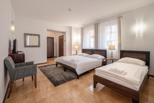 波兰尼卡-兹德鲁伊椴树旅馆的一间卧室配有两张床和椅子