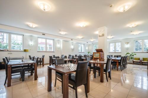 波兰尼卡-兹德鲁伊椴树旅馆的用餐室设有桌椅和窗户。