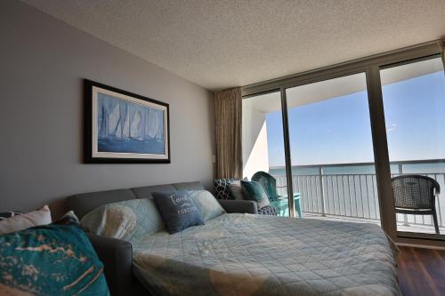 默特尔比奇Luxury 2 beds 2 bath Ocean Front Condo的一间卧室设有一张床和一个阳台