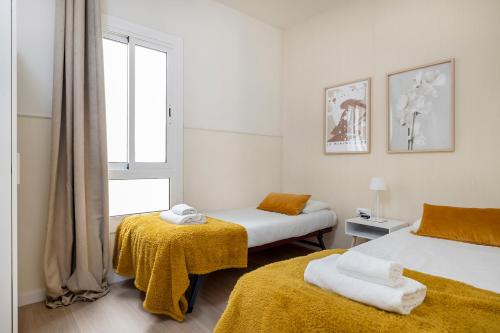 巴塞罗那萨塔圣家堂区公寓式酒店的一间卧室设有两张床和窗户。