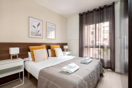 巴塞罗那萨塔圣家堂区公寓式酒店的一间卧室配有两张床,上面有毛巾