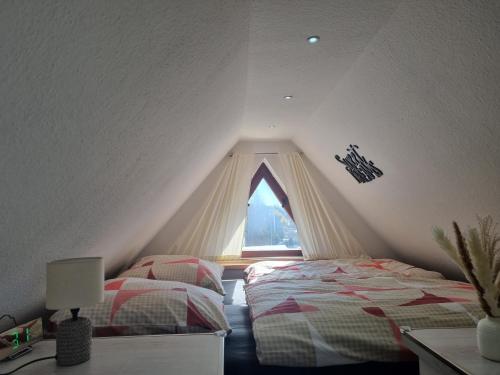 什未林Ostorfer See的阁楼卧室设有两张床和窗户。