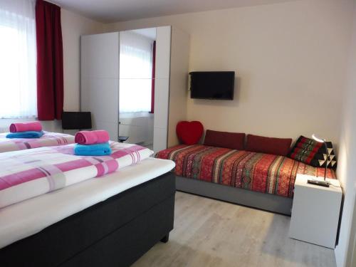 圣恩吉玛Komfortable Wohnungen und Studio in Sankt Englmar的酒店客房,设有两张床和一张沙发