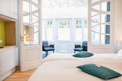 马尔梅迪赖斯布里特塞恩酒店的一间卧室配有两张床和两把椅子