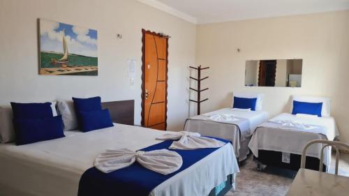 卡莫辛Hotel Camocim的蓝色和白色的客房内的两张床