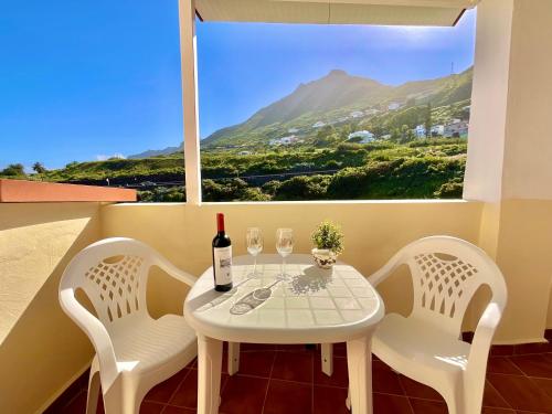 拉拉古纳F&M 'con terraza y tranquilidad'的一张带两把椅子的白色桌子和一瓶葡萄酒