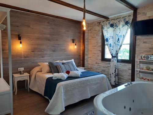 埃尔托尔诺Apartamento Rural Amaluna的一间卧室配有一张床和浴缸