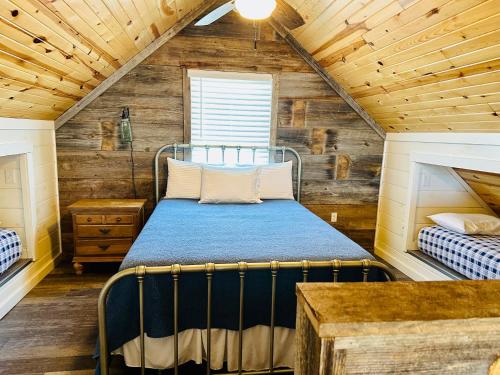 芒廷维尤Knotty Squirrel Cabins的卧室配有一张床铺,位于带木墙的房间内