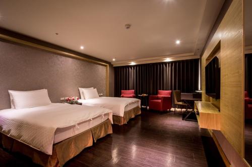 台南夏都富朗酒店的酒店客房带两张床和一张桌子以及椅子。