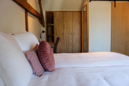 WestmalleDe Kasteelhoeve的卧室配有白色的床和2个枕头