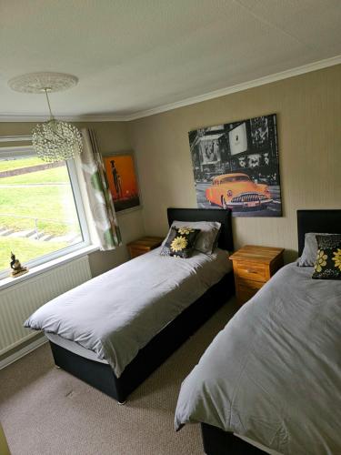 纽波特3 Bedroom family home Newport, Located next to M4的一间卧室设有两张床和窗户。