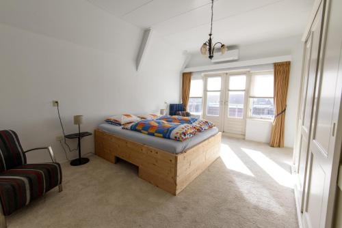 霍恩City House Hoorn的一间卧室配有一张床、一张沙发和窗户。