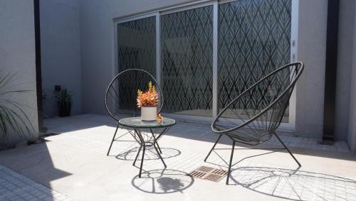 拉斐拉Casa Atilio -Dpto Premium con entrada autónoma的庭院里设有两把椅子和一张带蜡烛的桌子