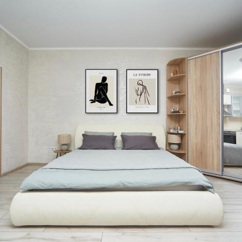 敖德萨Apartments Club Marine的卧室配有一张大床,墙上挂有两张照片