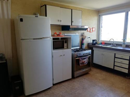 门多萨Aguara House Pedemonte Mendoza的厨房配有白色冰箱和炉灶。