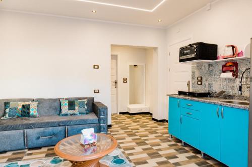 卢克索Villa golden life apartments, new property with pool access的客厅配有蓝色的沙发和桌子